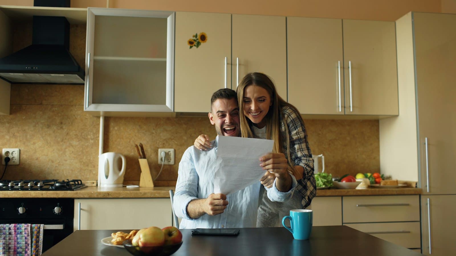 Couple happily reading a letter in their kitchen